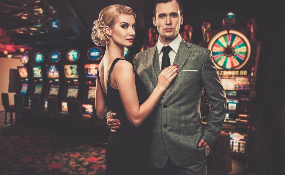Well dressed man and woman in a casino, by the slot machines