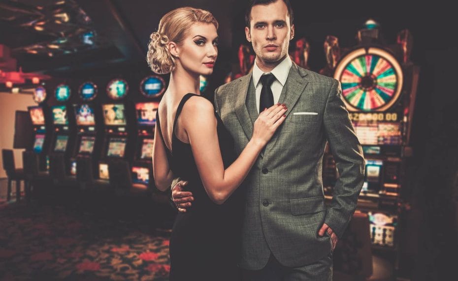 Well dressed man and woman in a casino, by the slot machines
