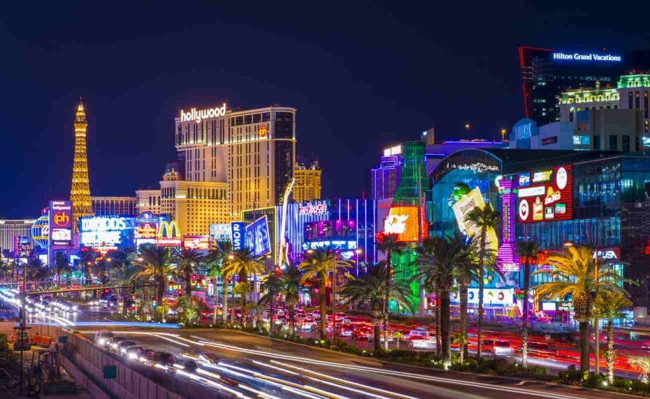 The Strip in Las Vegas, Nevada, at night with bright lights and palm trees.