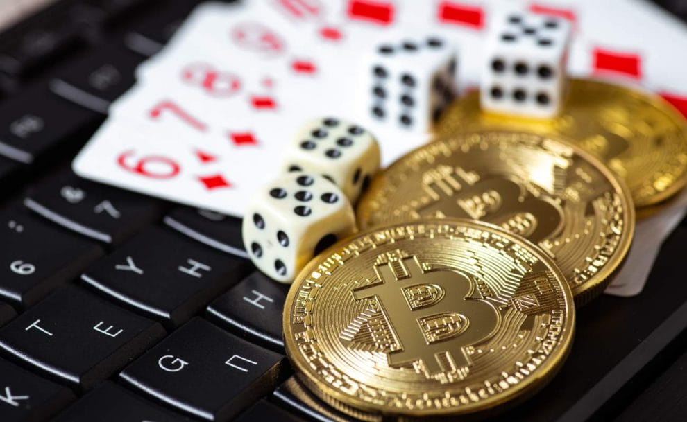 Bitcoins, cards and dice on keyboard.