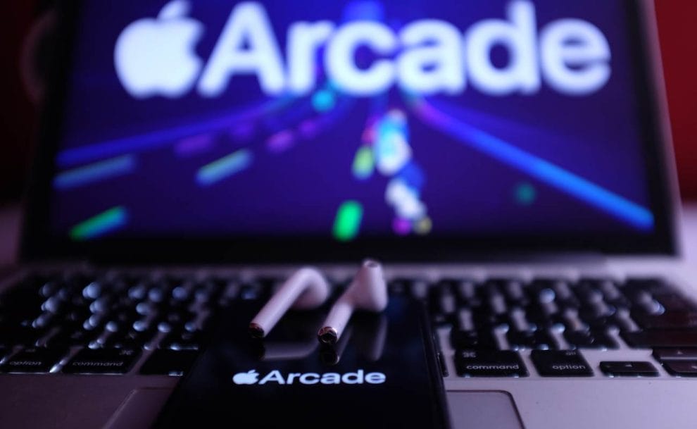 Apple Arcade displayed on iPhone and MacBook with AirPods.