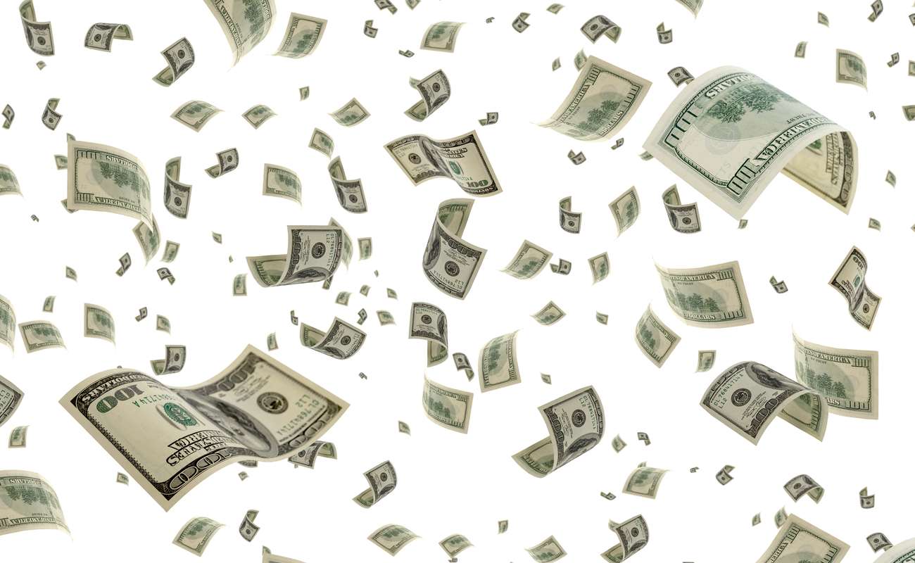 Lots of 100 dollar bills floating everywhere in front of a plain white background.