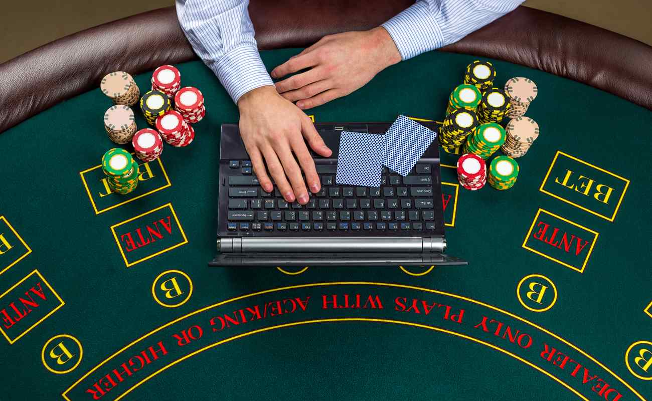 Someone on a laptop placed on a poker table 