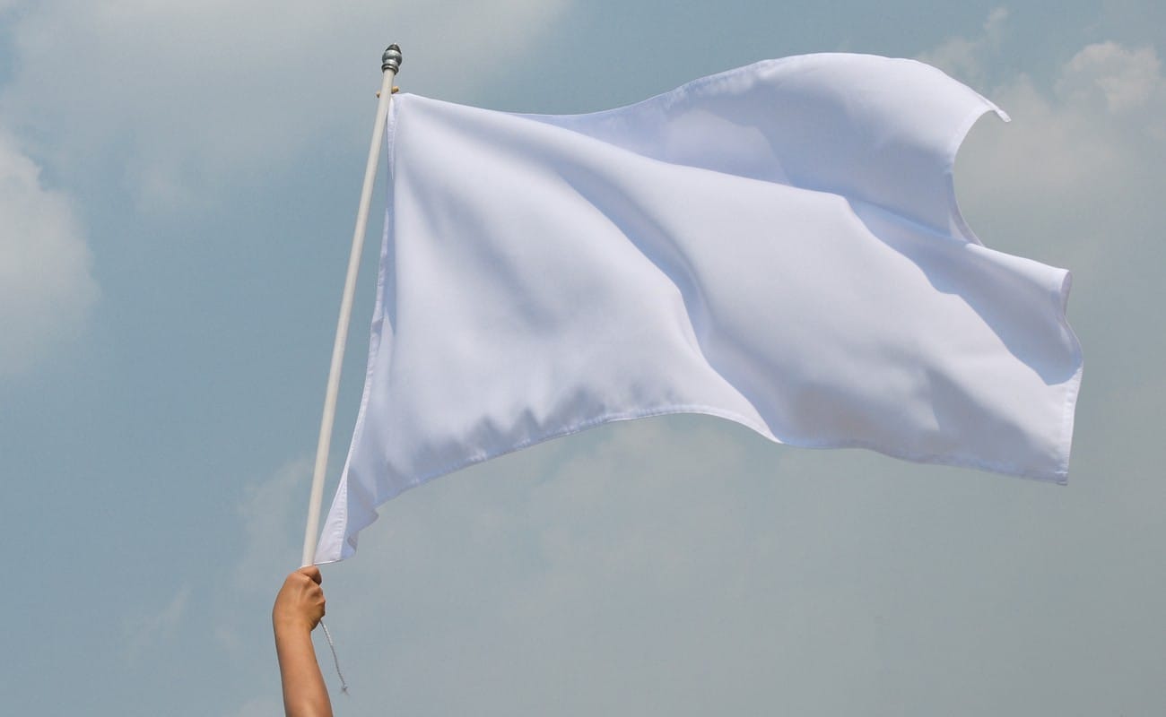 Someone holding a white flag in the air signaling surrender