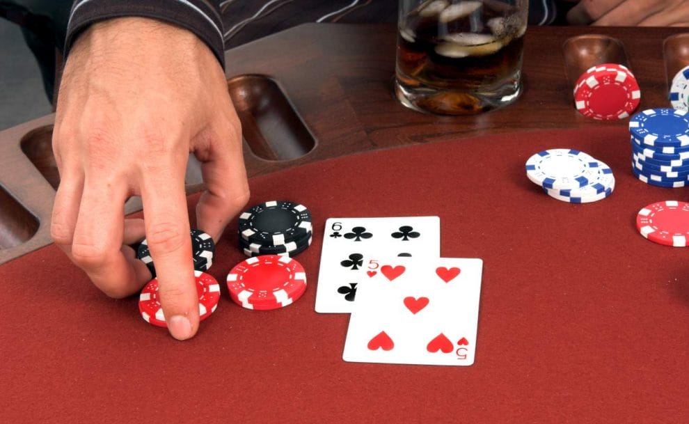 Someone’s hand about to move their chips to double down in poker game