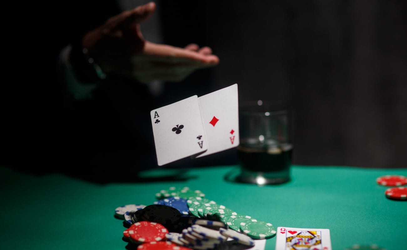 Someone throwing their cards on the poker table with poker chips