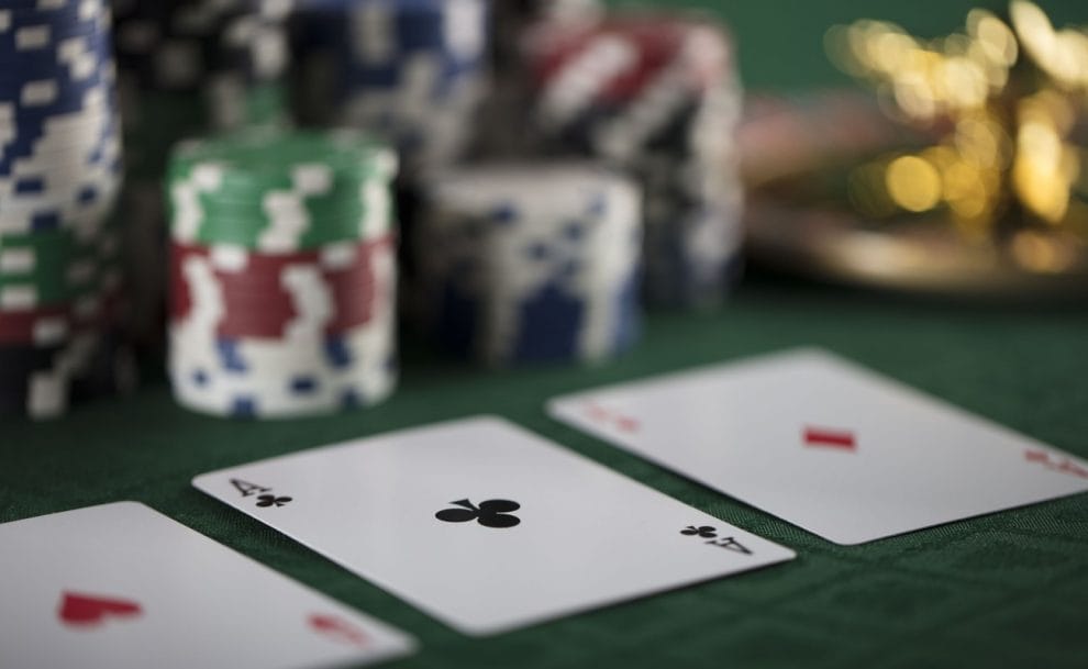 Concept of poker game with playing cards and poker chips on table.