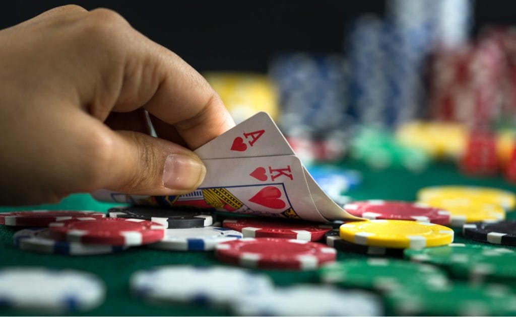 Player holding blackjack playing cards, chips on table