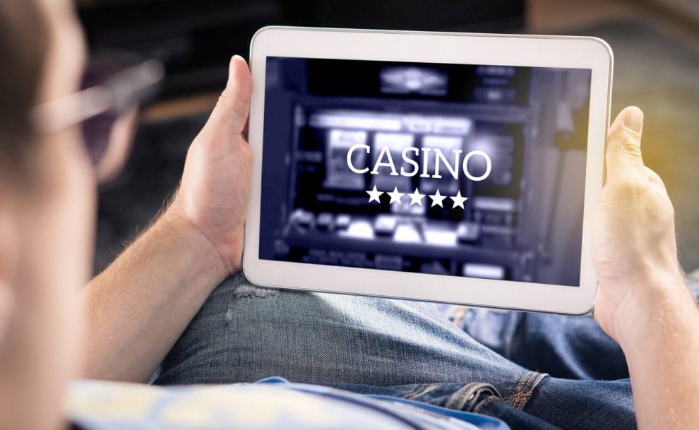 Man playing in an online casino with a tablet.