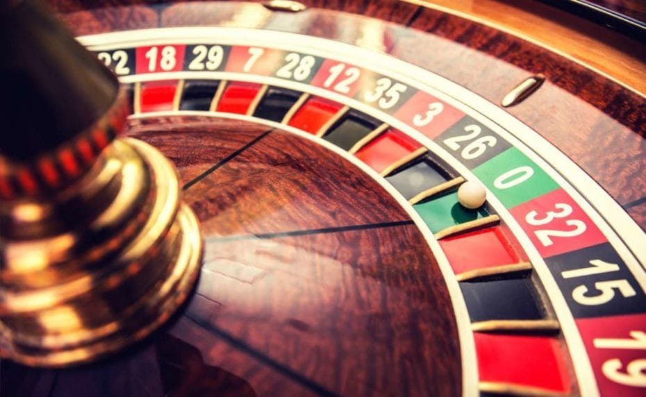 Roulette wheel in casino with the ball on green position zero.