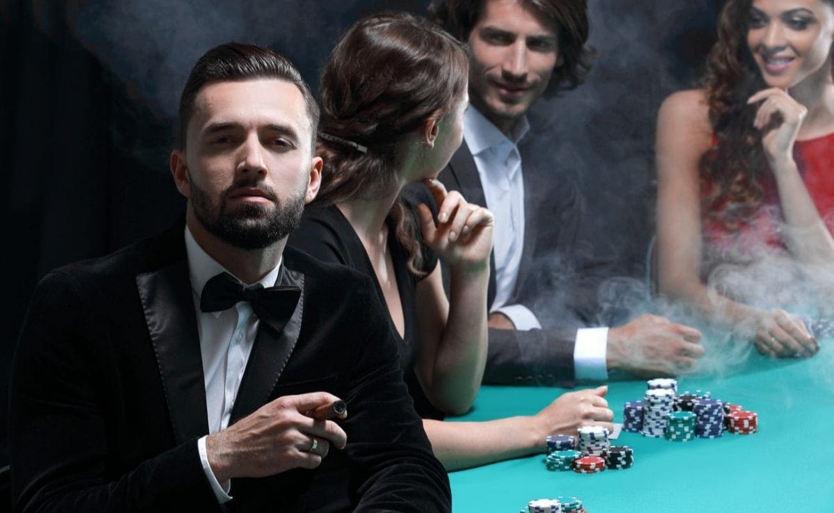 Man in tuxedo with cigar looking up from poker table in casino