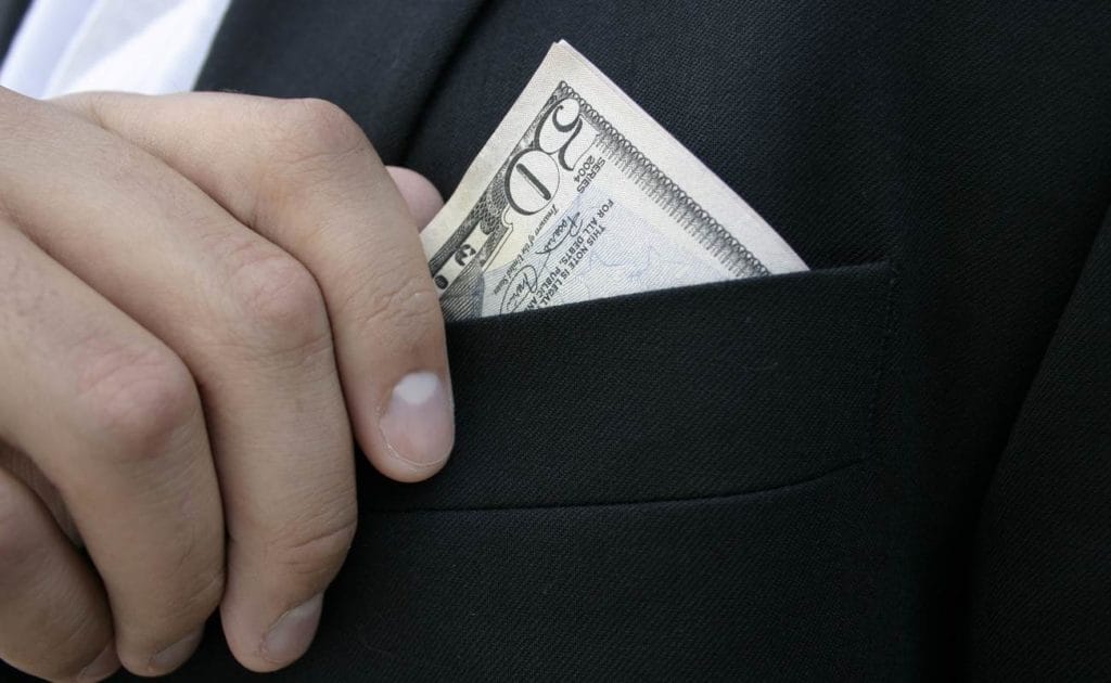 Close up of dollar bills in man's suit pocket