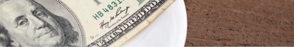 Dollar bills spread on plate as tip