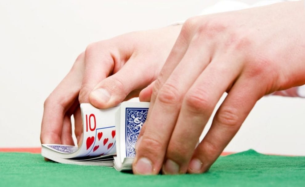 Hands shuffling cards with number 10 revealed