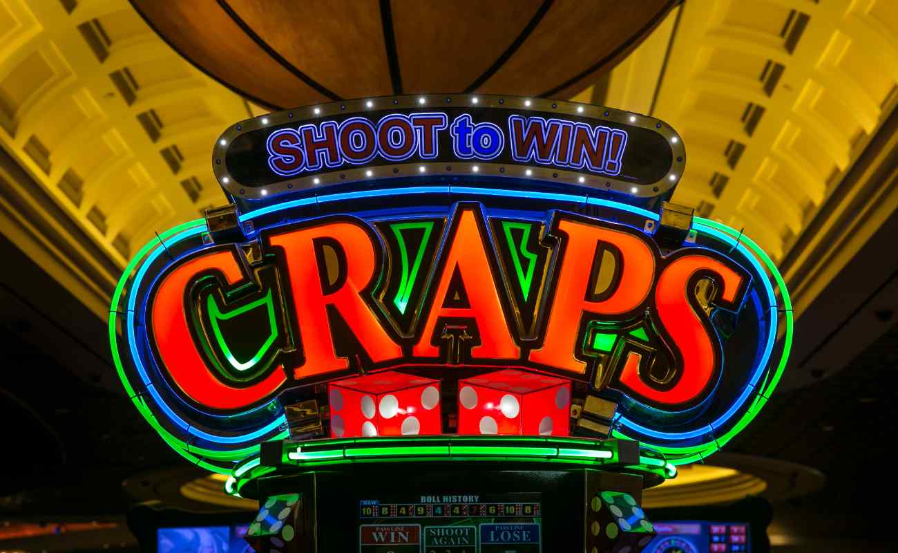 Neon-lit craps sign in casino saying Shoot to Win! above it