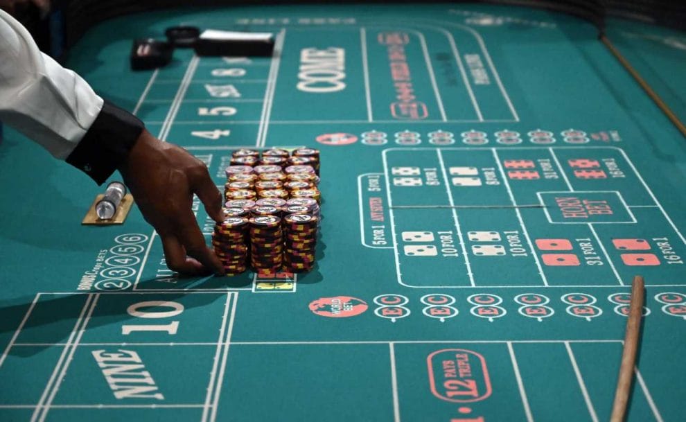 Close up of the hands of a craps dealer preparing stacks of casino chips