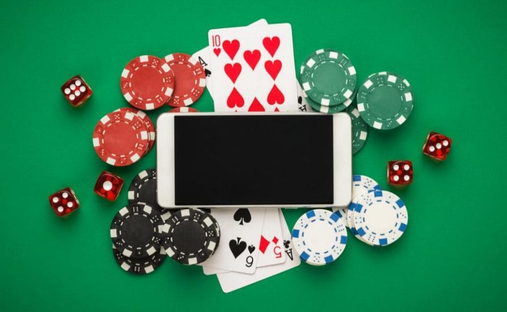 Mobile phone on casino table surrounded by chips and dice