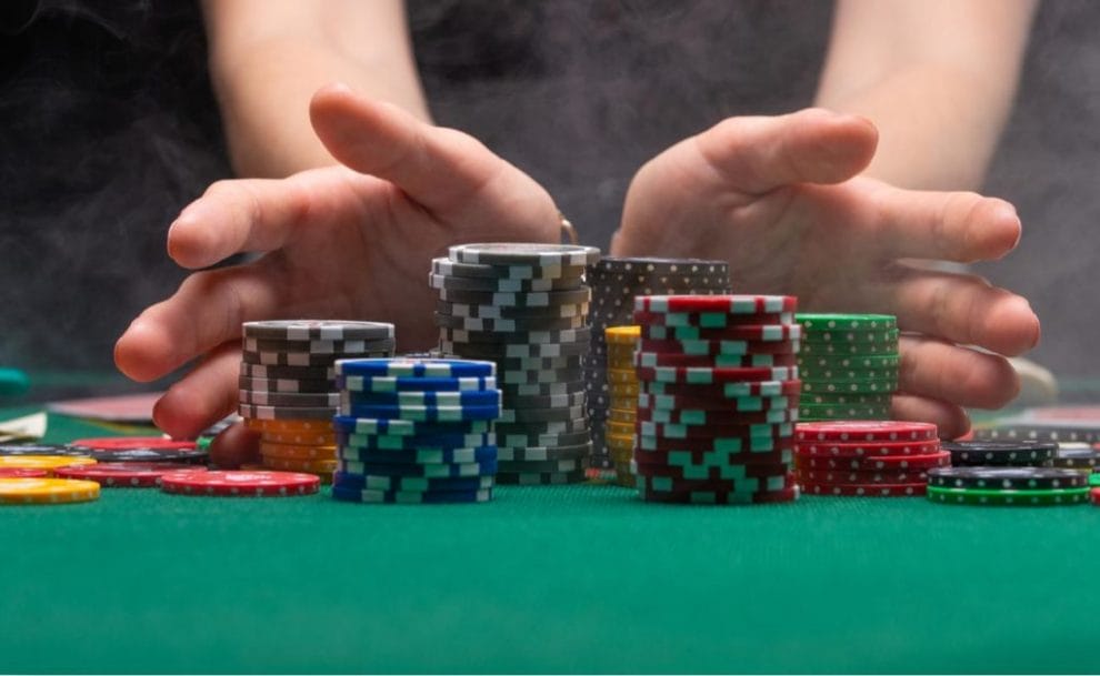 Close up of hands holding stacks of gambling chips