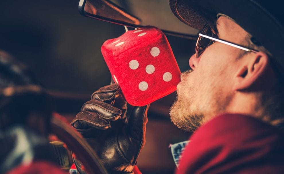 Feeling lucky concept closeup of a man kissing a large red die toy