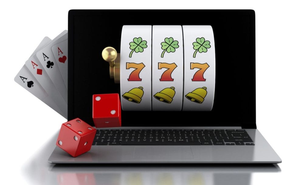 Concept of online slot on laptop with red dice and playing cards in the background
