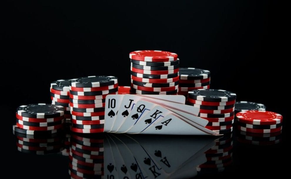 poker chips and cards on black surface and background