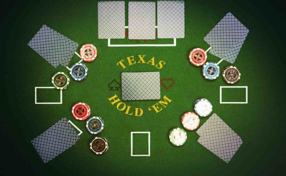 Texas Hold'em game played on green felt table with cards and poker chips