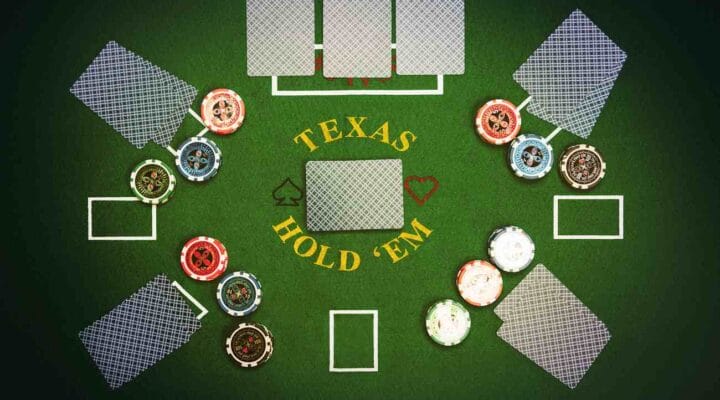 Texas Hold'em game played on green felt table with cards and poker chips