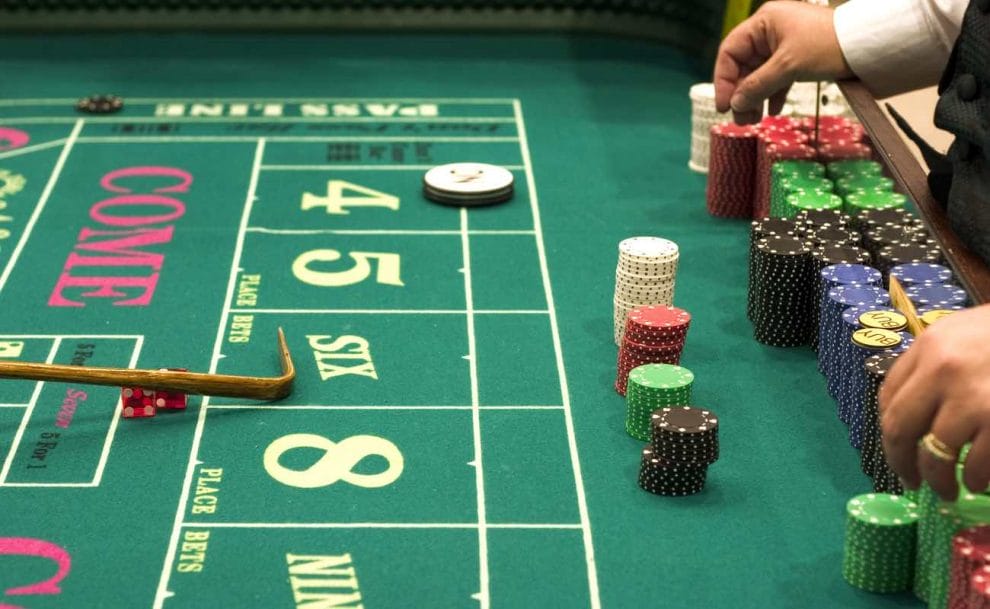 Closeup of a casino craps table with the croupier sorting casino chips