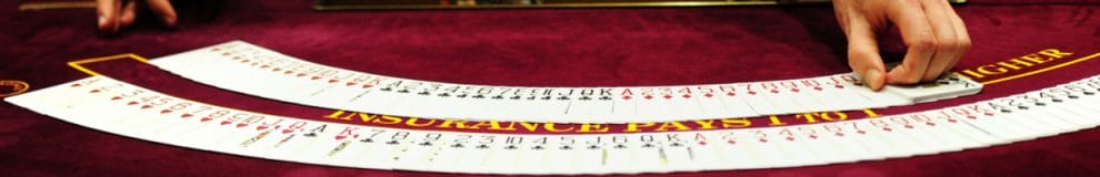 Croupier fans out playing cards on a casino table.