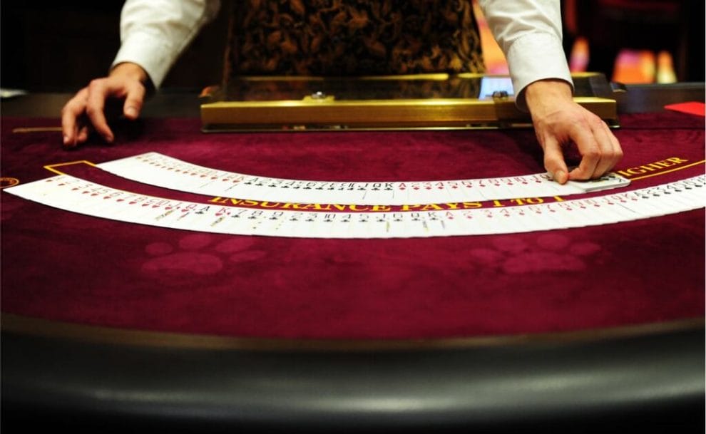 Croupier fans out playing cards on a casino table.