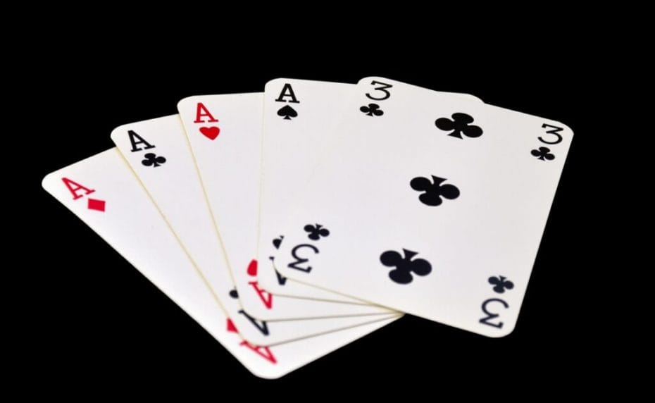 A four-of-a-kind poker hand with four aces and a three of clubs.