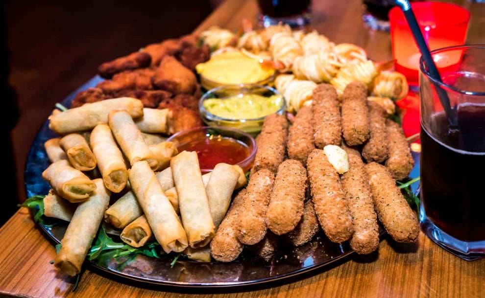 A platter of different finger foods sitting on a table with a drink.