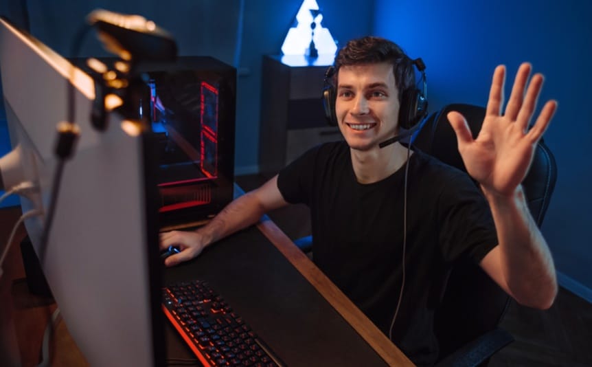 A young streamer waves to his audience through his webcam.