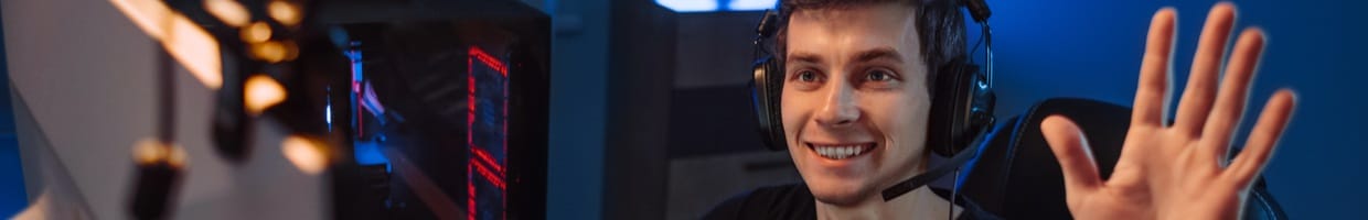 A young streamer waves to his audience through his webcam.