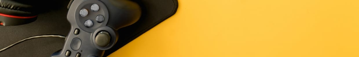 A video game controller sits on a yellow table.
