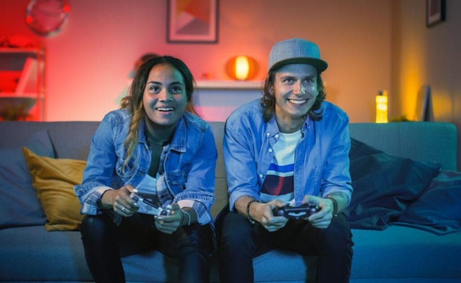 A young couple play video games in front of the TV.