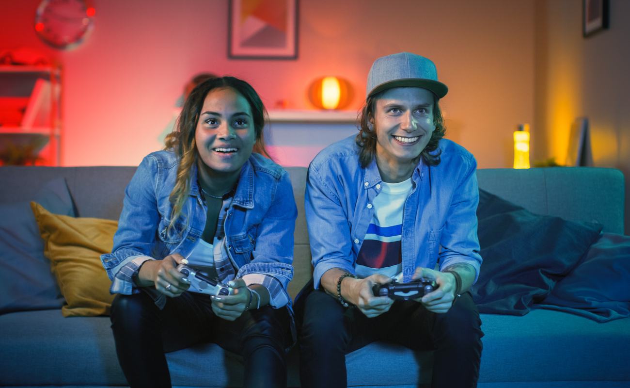 A young couple play video games in front of the TV.