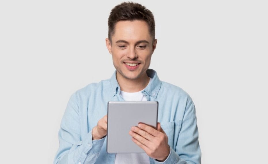 A young man plays online bingo on his tablet.