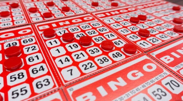 Several bingo cards with several numbers covered by bingo chips.