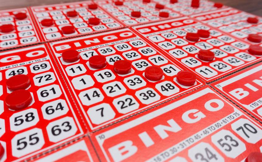 Several bingo cards with several numbers covered by bingo chips.