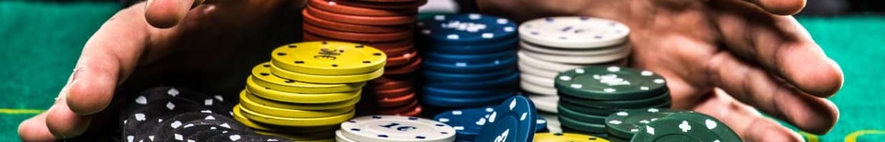 close up of poker player with chips at a green casino table