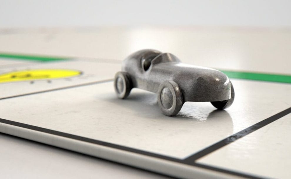 A toy metal car is placed on a board game.
