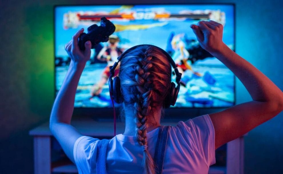 A woman celebrates while playing an online fighting game.