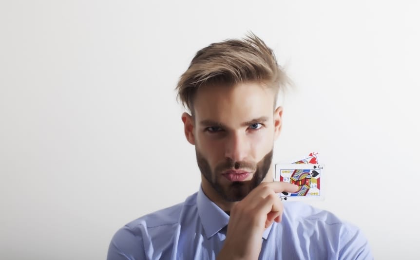 Young businessman holding a pair of cards against a white background.