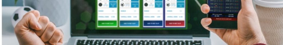 Front view of a man using his laptop and smartphone for making sports bets online.