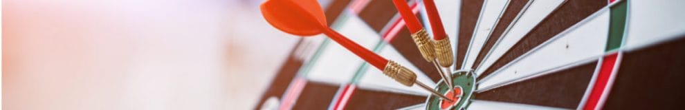 Close-up of a dartboard with bullseye darts against a blurred background.