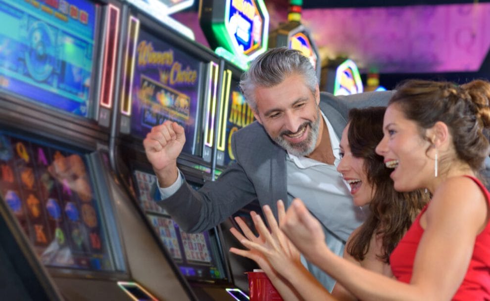 A happy group of people playing casino slot machines.