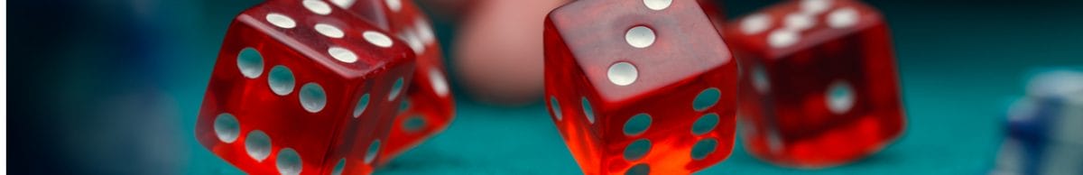Red dice bouncing onto a casino table.
