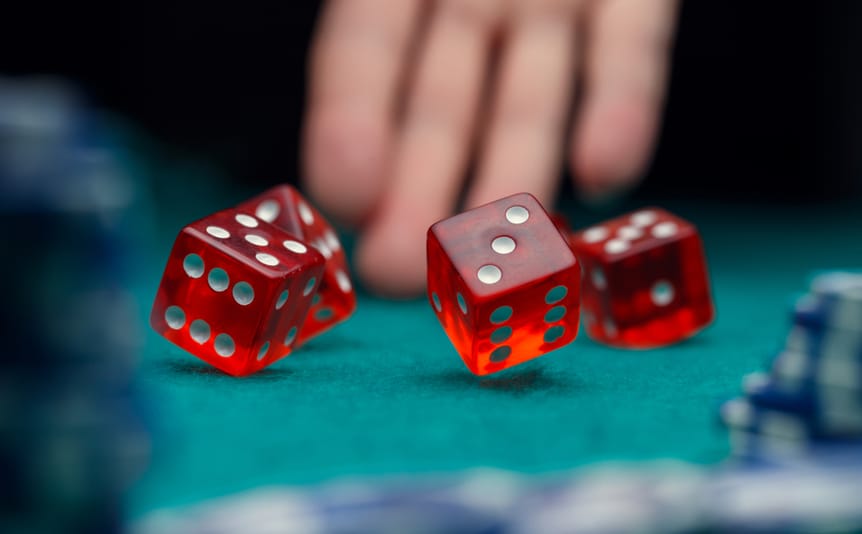 Red dice bouncing onto a casino table.