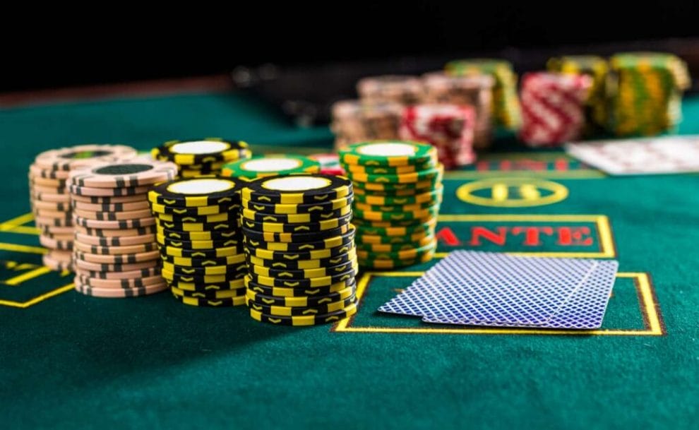 Piles of differently colored chips on a casino poker table.
